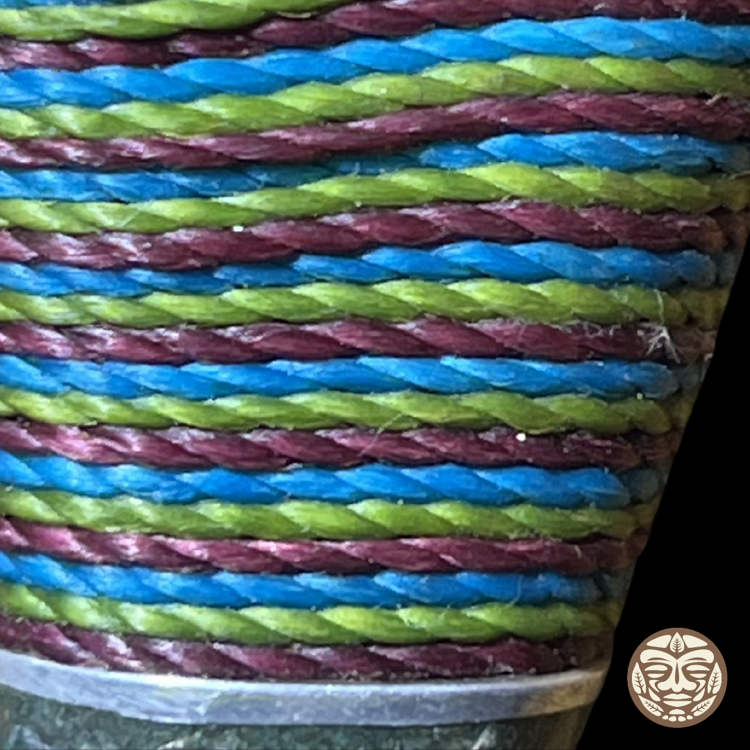 A close-up of a braided chambira rope kuripe with repeating horizontal stripes in blue, and lime green.