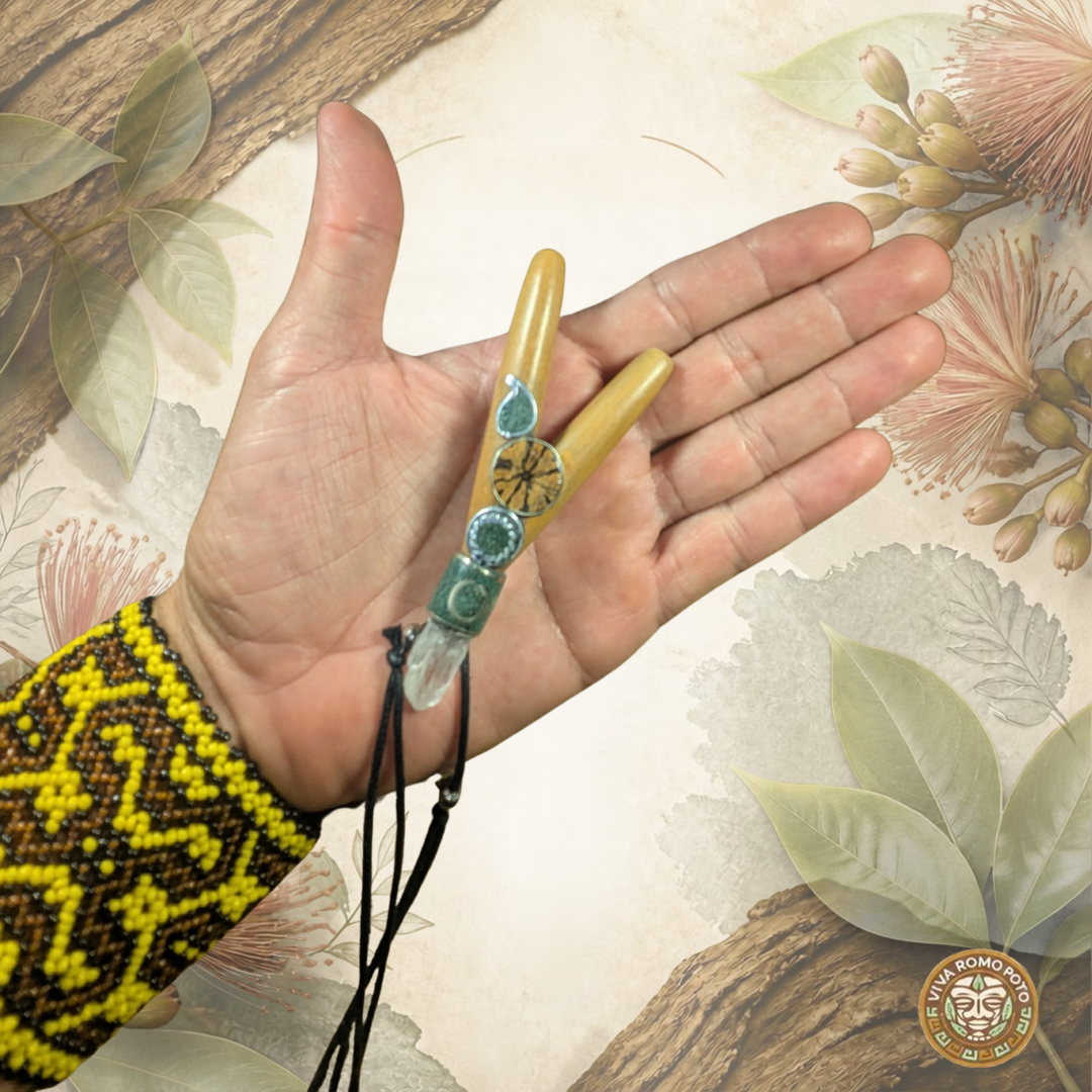 A hand with a Shipibo bracelet on the wrist holding and showing a  Bobinsana wood Kuripe with Ayahuasca talisman, clear quartz and aplaca silver.  With a Bobinsana backround.  It has the title Bobinsana Wood Kuripe and the Viva Romo Poto logo bottom left corner.